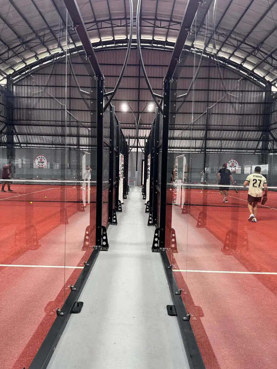 The glass-walled corridor between the two courts at Padel Bros